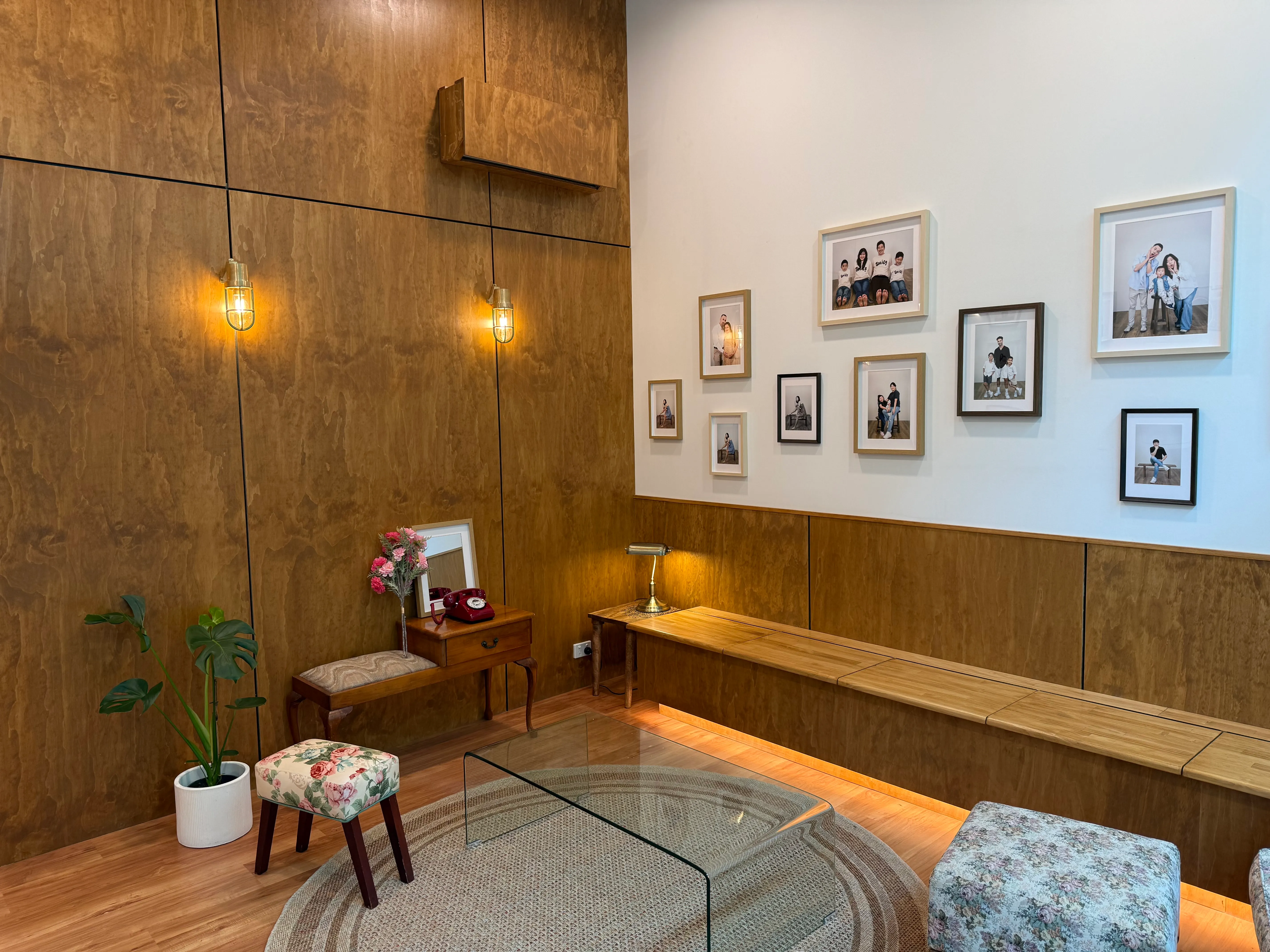 The Selforait Studio lobby in Northbridge — timber panelling, brass sconces, a vintage red telephone and a wall of framed client portraits