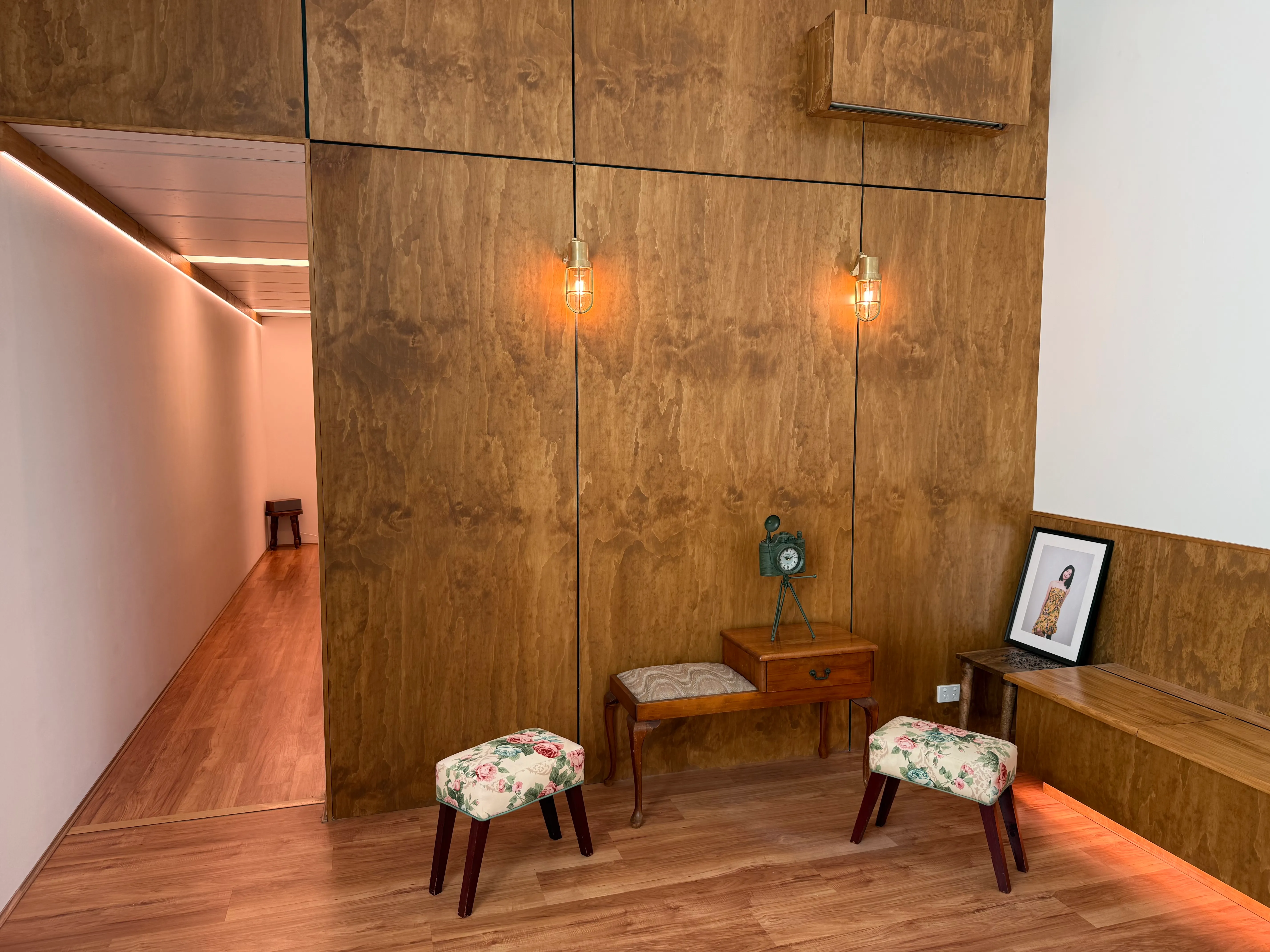The lobby of Selforait Studio — warm timber walls, brass sconces and fresh flowers